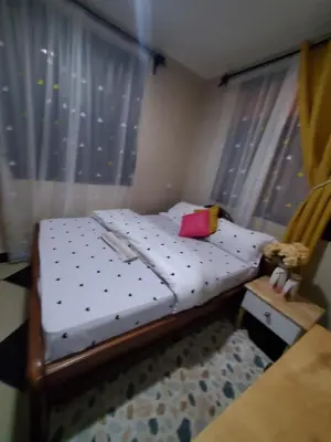 a small bed in a room with a window at divine favour homestay in Arusha