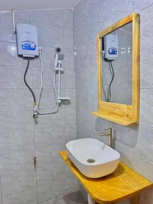 a bathroom with a sink and a mirror at J&T Homestay in Karatu