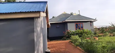 a small blue house with a blue roof at J&T Homestay in Karatu