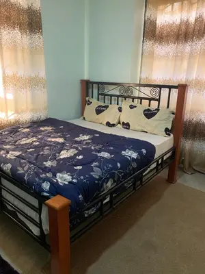 a bedroom with a bed with a blue blanket and pillows at Datogga Homestay in Kitumbeine
