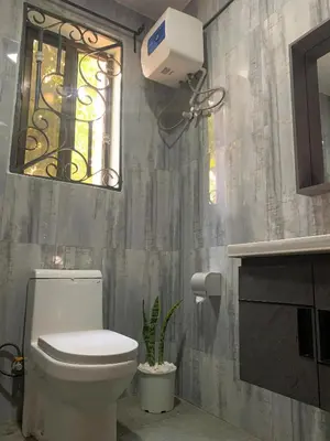 a bathroom with a white toilet and a window at Datogga Homestay in Kitumbeine