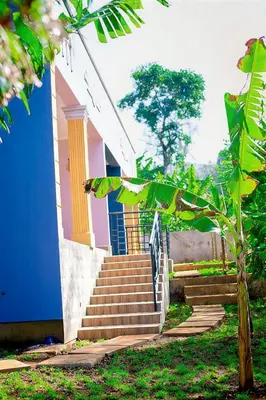 a pink and blue house with stairs in front at Materuni Home Stay in Uru East