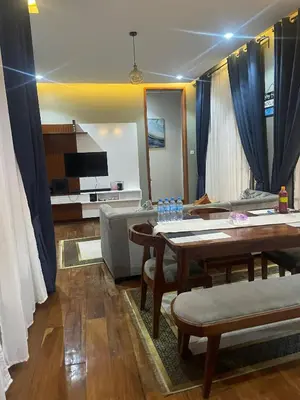 a living room with a table and a couch at Lavish 2 Bedroom in Arusha