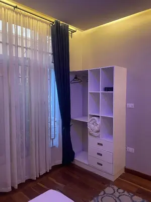 a white cabinet in a room with a window at Lavish 2 Bedroom in Arusha