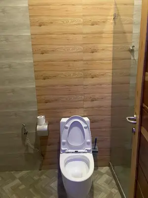 a bathroom with a toilet with the seat up at Lavish 2 Bedroom in Arusha