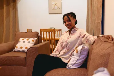 a woman sitting on a couch in a living room at FREEDOM homes in Arusha
