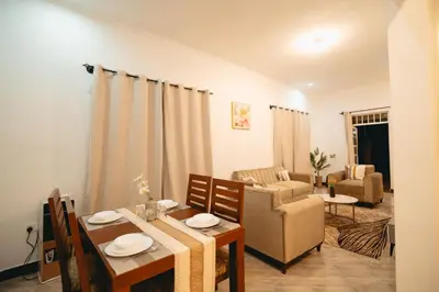 a living room with a table and a dining room at FREEDOM homes in Arusha