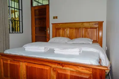 a bed with two white towels on top of it at Chaga African Home in Moshi