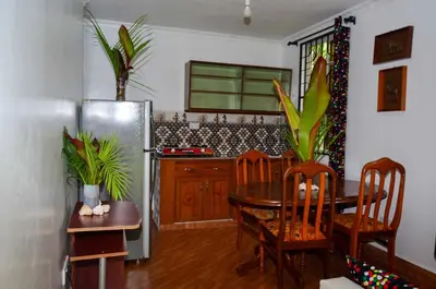 a kitchen with a table and a refrigerator at Chaga African Home in Moshi