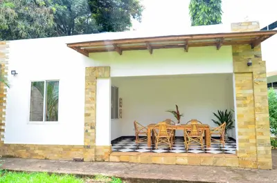 a patio with a table and chairs on it at Chaga African Home in Moshi
