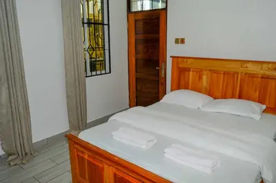 a bedroom with a bed with two white towels on it at Chaga African Home in Moshi