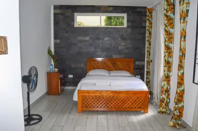 a bedroom with a wooden bed and a window at Chaga African Home in Moshi