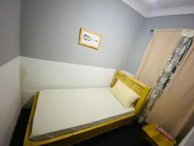 a small bed in a room with a picture on the wall at Tulivu house in Arusha
