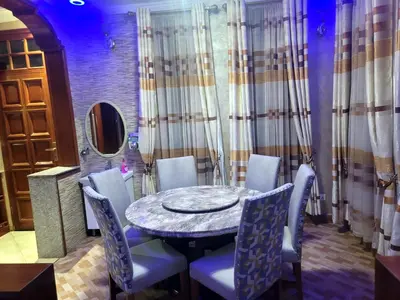 a dining room with a round table and blue chairs at Cape Villa in Arusha