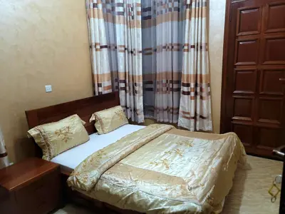 a small bedroom with a bed and a curtain at Cape Villa in Arusha