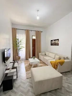 a living room with a couch and a tv at Haven Retreat in Arusha