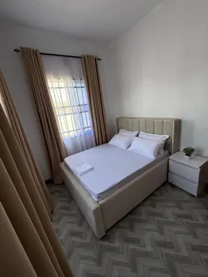 a bedroom with a large bed with a window at Haven Retreat in Arusha