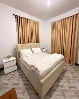a bedroom with a large bed and curtains at Haven Retreat in Arusha