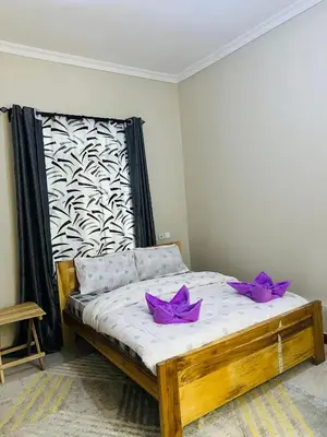a bedroom with a bed with purple bows on it at The Black Mamba in Arusha