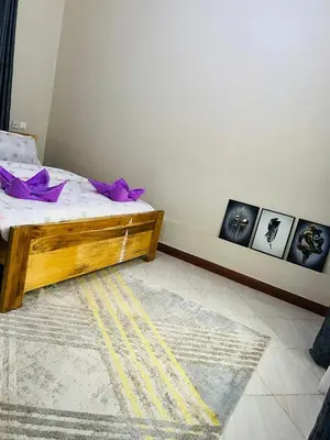 a bedroom with a bed with purple pillows on it at The Black Mamba in Arusha