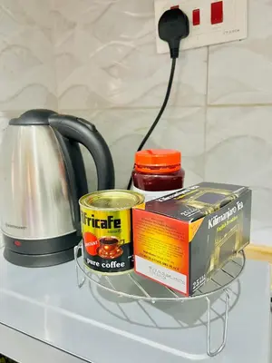 a tea pot and a book on a counter with a coffee pot at The Black Mamba in Arusha
