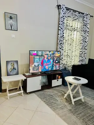 a living room with a flat screen tv and a table at The Black Mamba in Arusha