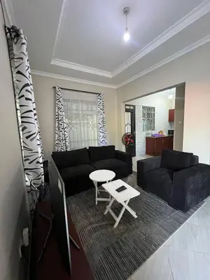 a living room with a black couch and a table at The Black Mamba in Arusha