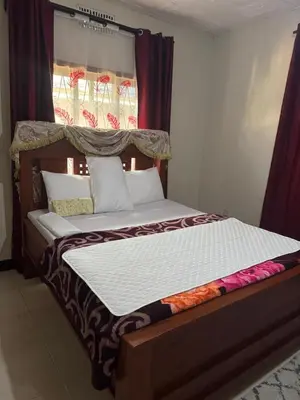 a large bed in a bedroom with a window at Njiro Rented 3 Bedroom House in Themi