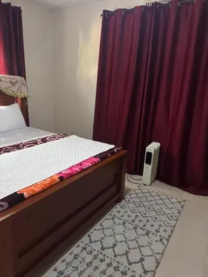 a bedroom with a bed and purple curtains and a rug at Njiro Rented 3 Bedroom House in Themi