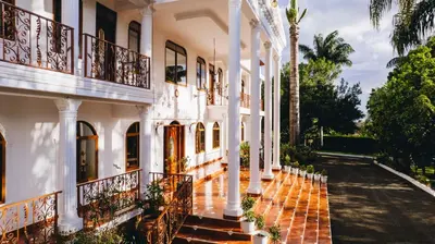 an exterior view of a white building with balconies at Naibor Villa in Themi