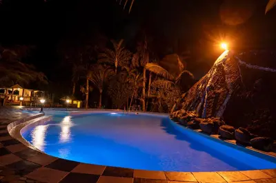 a swimming pool at night with blue lighting at Naibor Villa in Themi