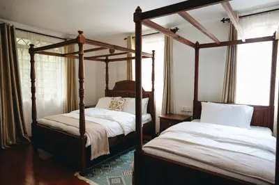 two four poster beds in a bedroom with at Naibor Villa in Themi