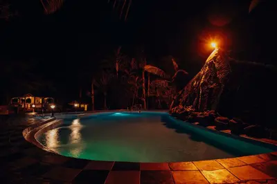a swimming pool at night with a street light at Naibor Villa in Themi