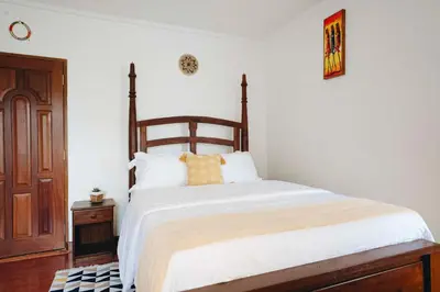a bedroom with a large bed with a wooden headboard at Naibor Villa in Themi