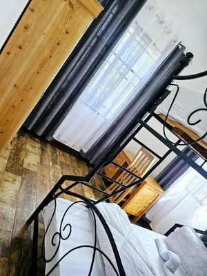 a metal bed in a room with a large window at Kinyanjui's homes 004 in Kirua
