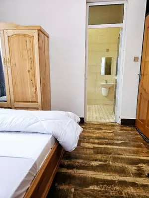 a bedroom with a bed and a bathroom with a shower at Kinyanjui's homes 004 in Kirua