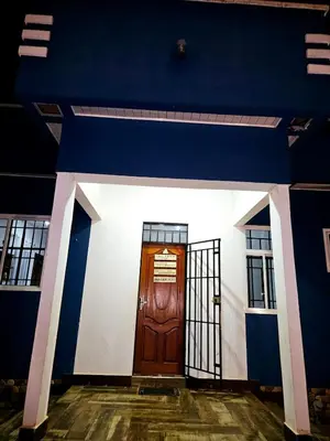 a blue and white building with a wooden door at Kinyanjui's homes 004 in Kirua
