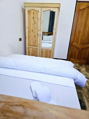 a room with three beds and a mirror at Kinyanjui's homes 004 in Kirua