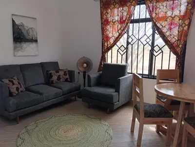 a living room with a couch and a chair and a table at Nyumbani House in Mto wa Mbu