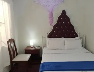 a bedroom with a bed with a red headboard and a chair at Barrenjourney Africa in Arusha