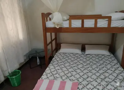 a small bedroom with two bunk beds and a table at Barrenjourney Africa in Arusha