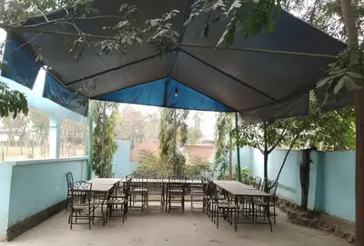 a group of tables and chairs under a blue umbrella at Barrenjourney Africa in Arusha