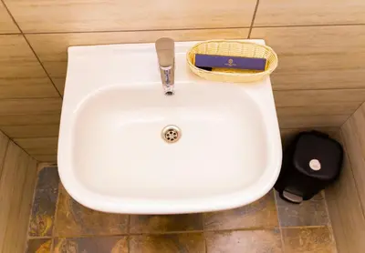 a white sink in a bathroom with a basket at Lastanza Safari Lodge in Moshi