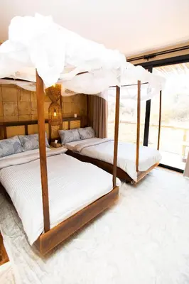 a bedroom with two bunk beds with white sheets at Shibam Campsite in Naberera