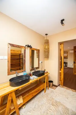 a bathroom with two sinks and a mirror at Shibam Campsite in Naberera