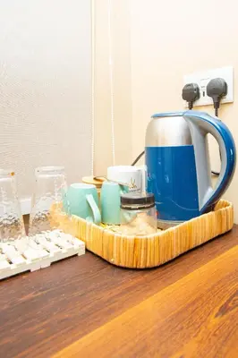 a blue tea kettle and cups on a table at Shibam Campsite in Naberera