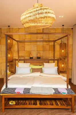 a bedroom with a large bed with a large chandelier at Shibam Campsite in Naberera