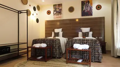 a bedroom with two beds and two tables with stuffed animals on them at Sunset Retreat Hotel in Arusha