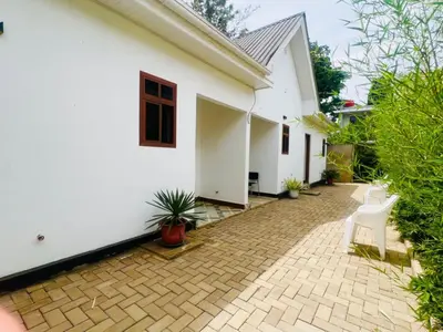 a white house with two white chairs and a patio at Sunset Retreat Hotel in Arusha
