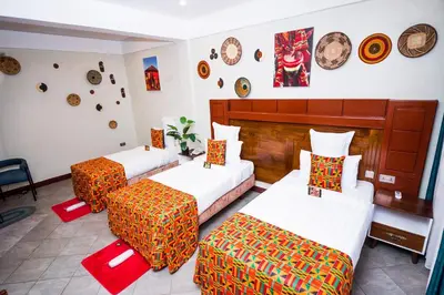 a room with two beds and two ottomans at Sunset Retreat Hotel in Arusha